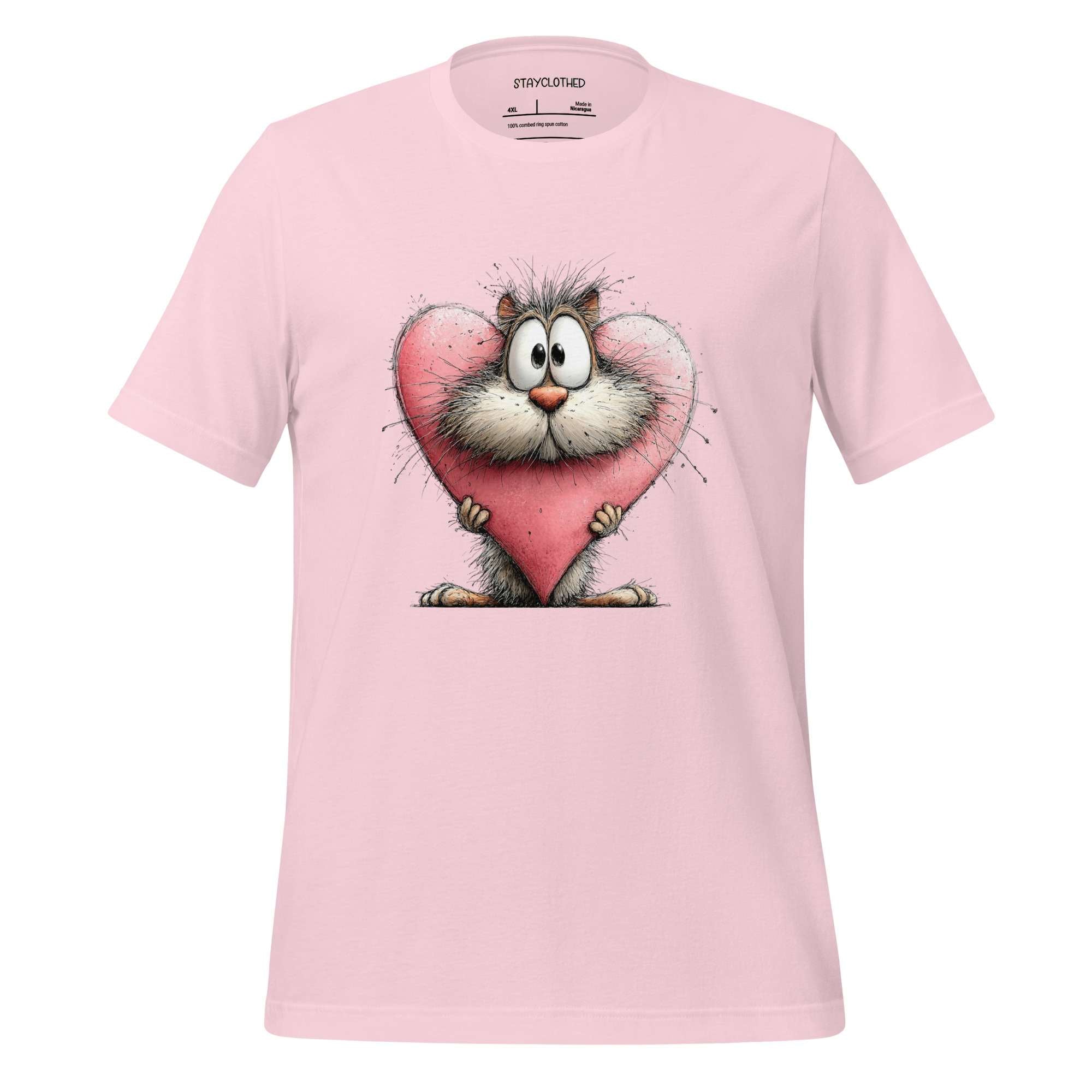 Pink t-shirt with a cartoon cat holding a heart on a wooden surface, featuring the brand 'StayClothed'.