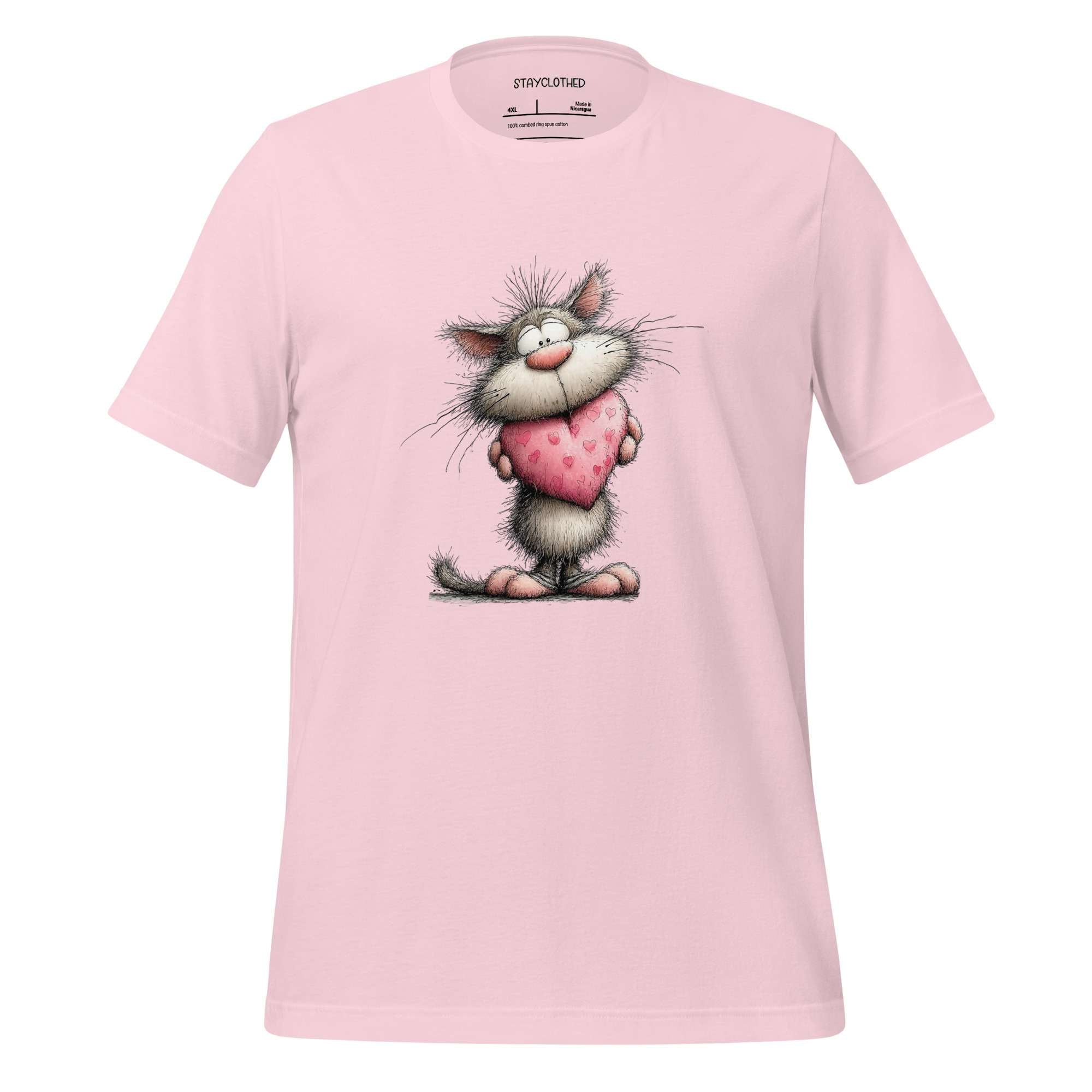 Pink t-shirt with a cartoon cat holding a heart on a wooden surface, branded 'StayClothed'.