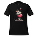 Black t-shirt with a cartoon cat holding a heart on a wooden surface, featuring the brand 'StayClothed'.