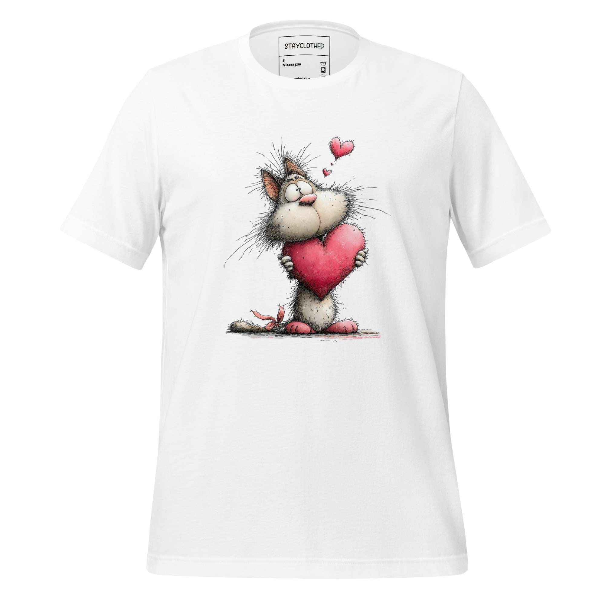 White t-shirt with a cartoon cat holding a heart on a wooden surface, featuring the brand 'StayClothed'.