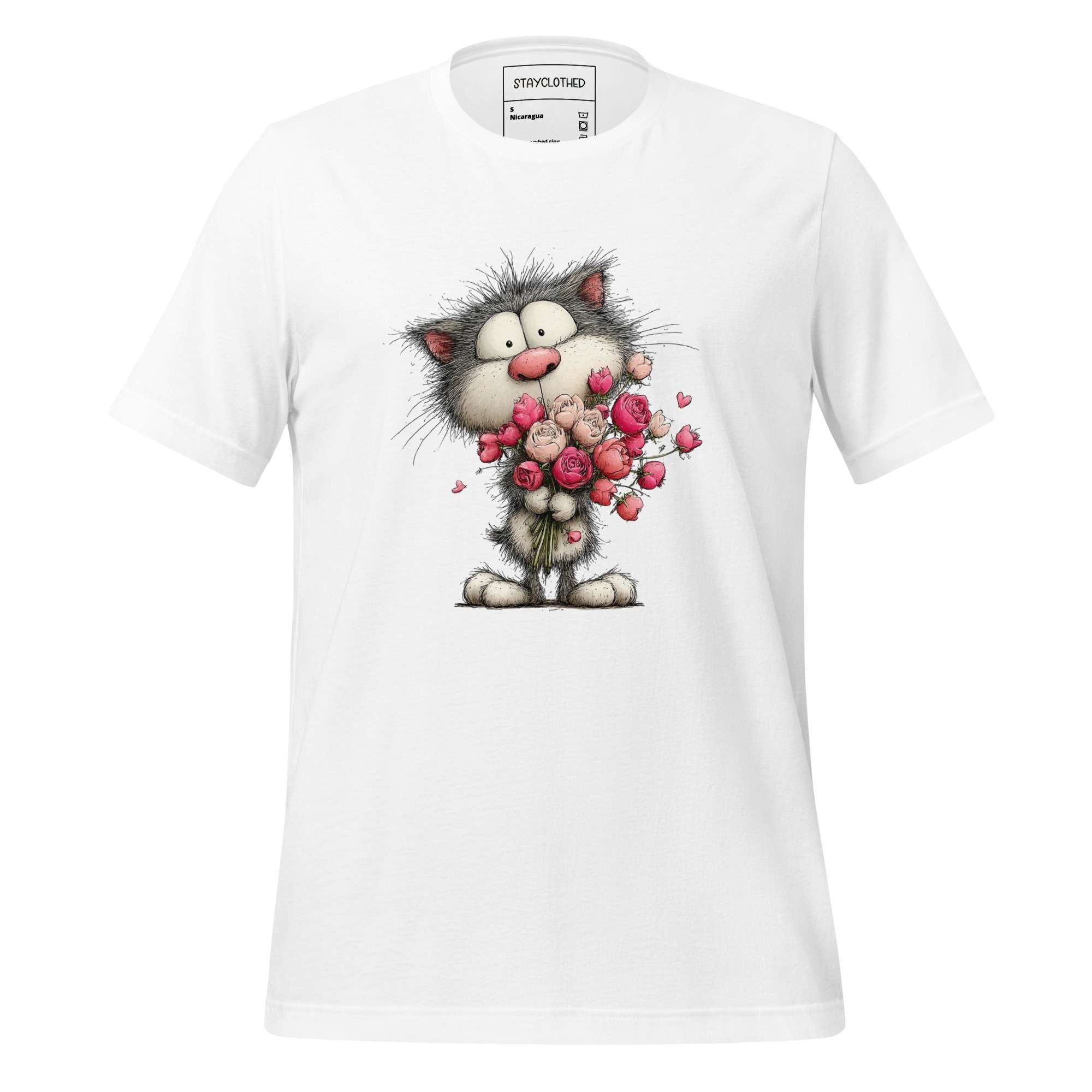 White t-shirt with a cartoon cat holding flowers on a wooden surface, featuring the brand 'StayClothed'.