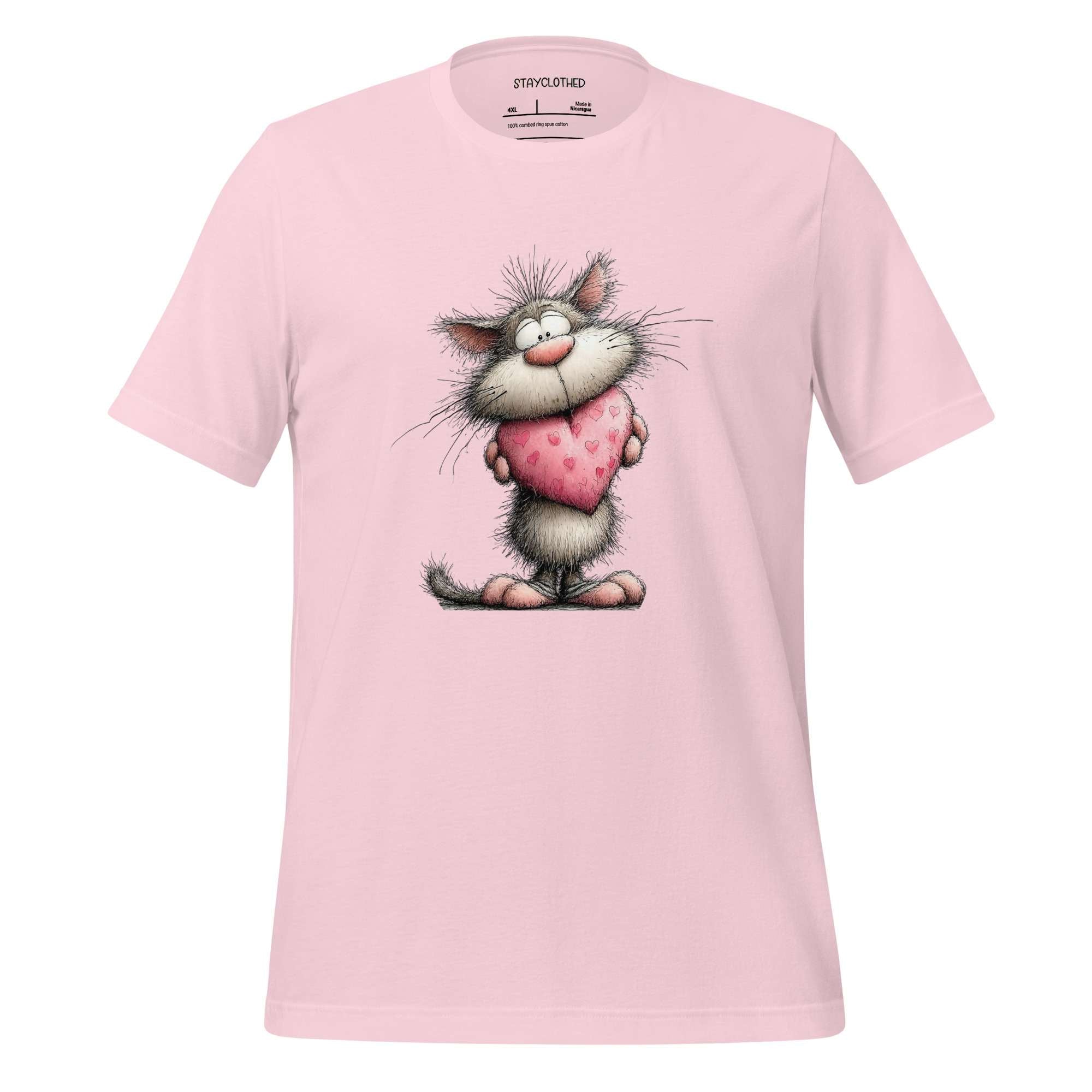 Pink t-shirt with a cartoon cat holding a heart on a wooden surface, branded 'StayClothed'.