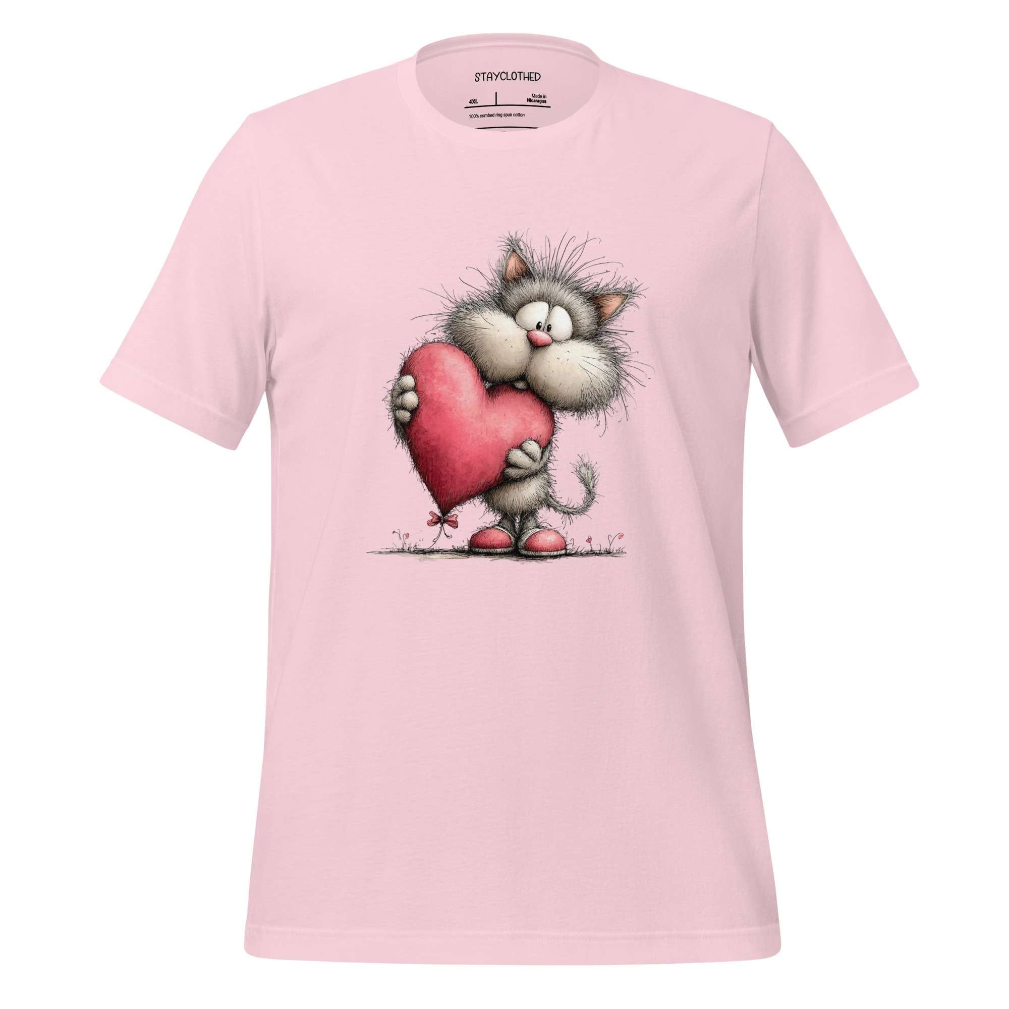 Pink t-shirt with a cartoon cat holding a heart on a wooden surface, branded 'StayClothed'.