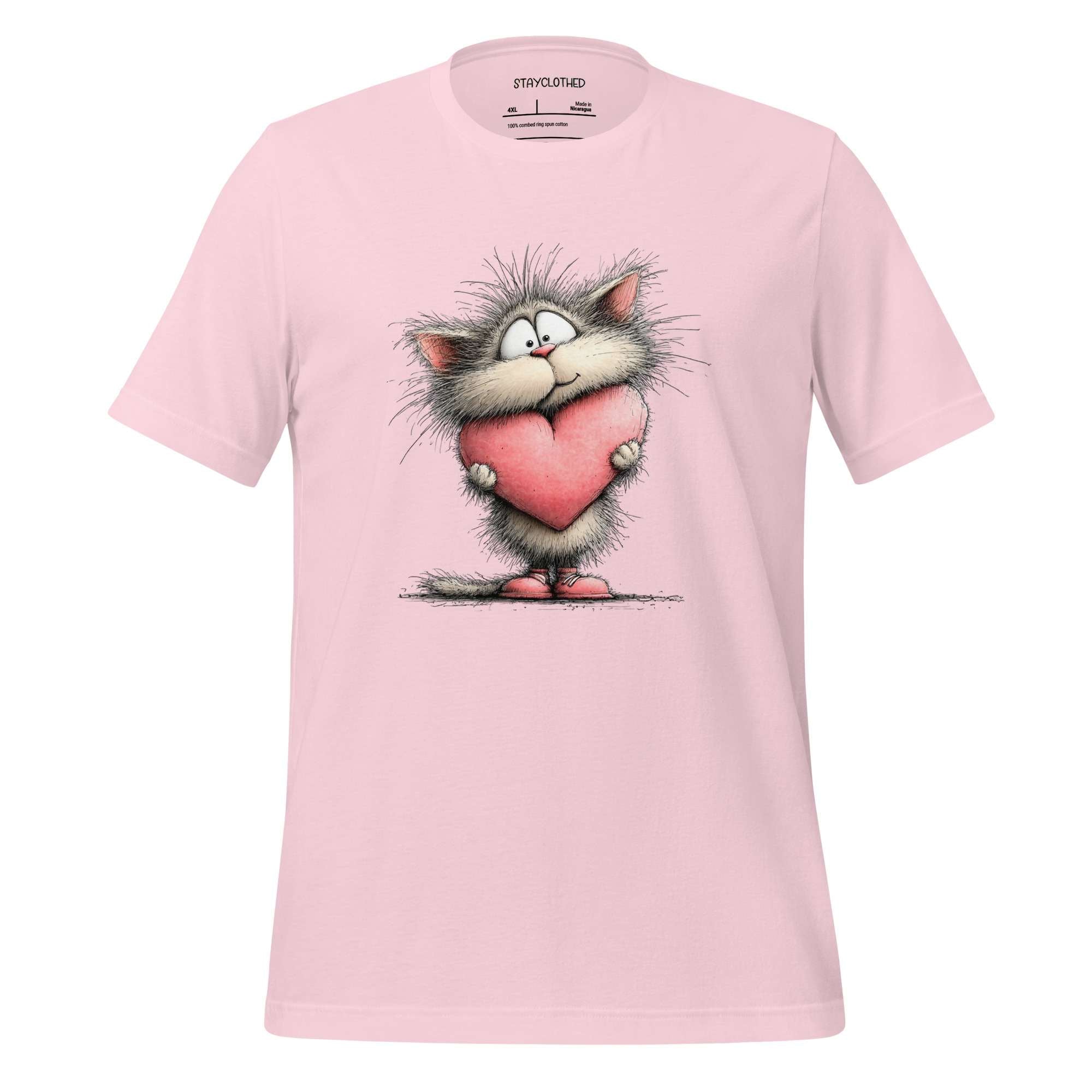 Pink t-shirt with a cartoon cat holding a heart on a wooden surface, featuring the brand 'StayClothed'.