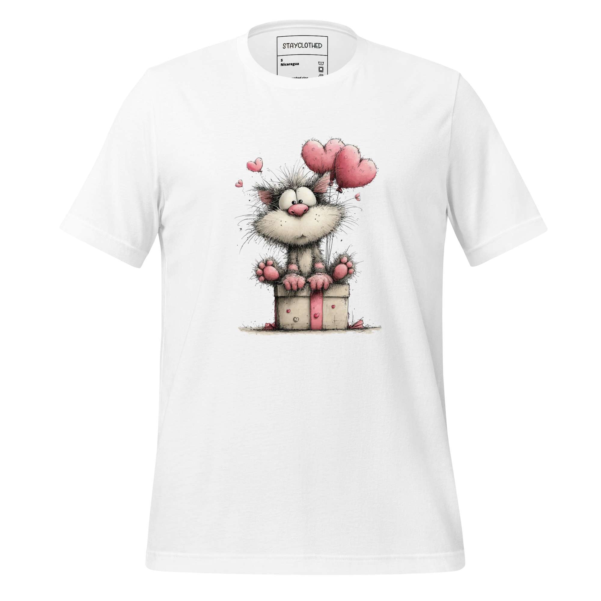 White t-shirt with cartoon cat design on a wooden surface, featuring the brand 'StayClothed'.