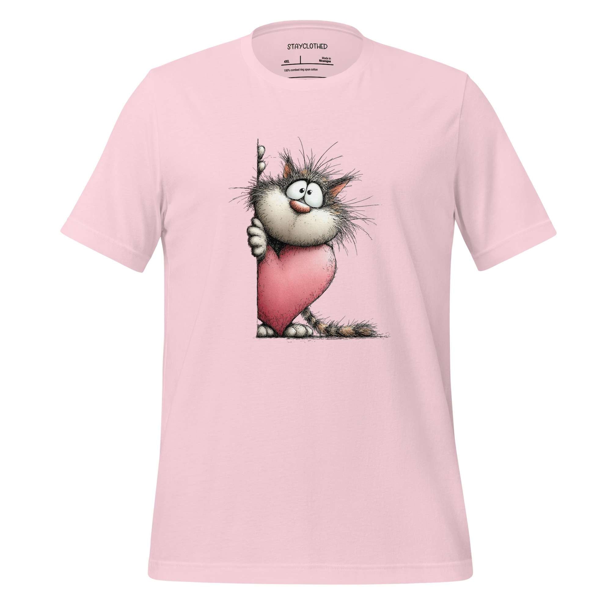 Pink t-shirt with cartoon cat design on a wooden surface, featuring the brand 'StayClothed'.