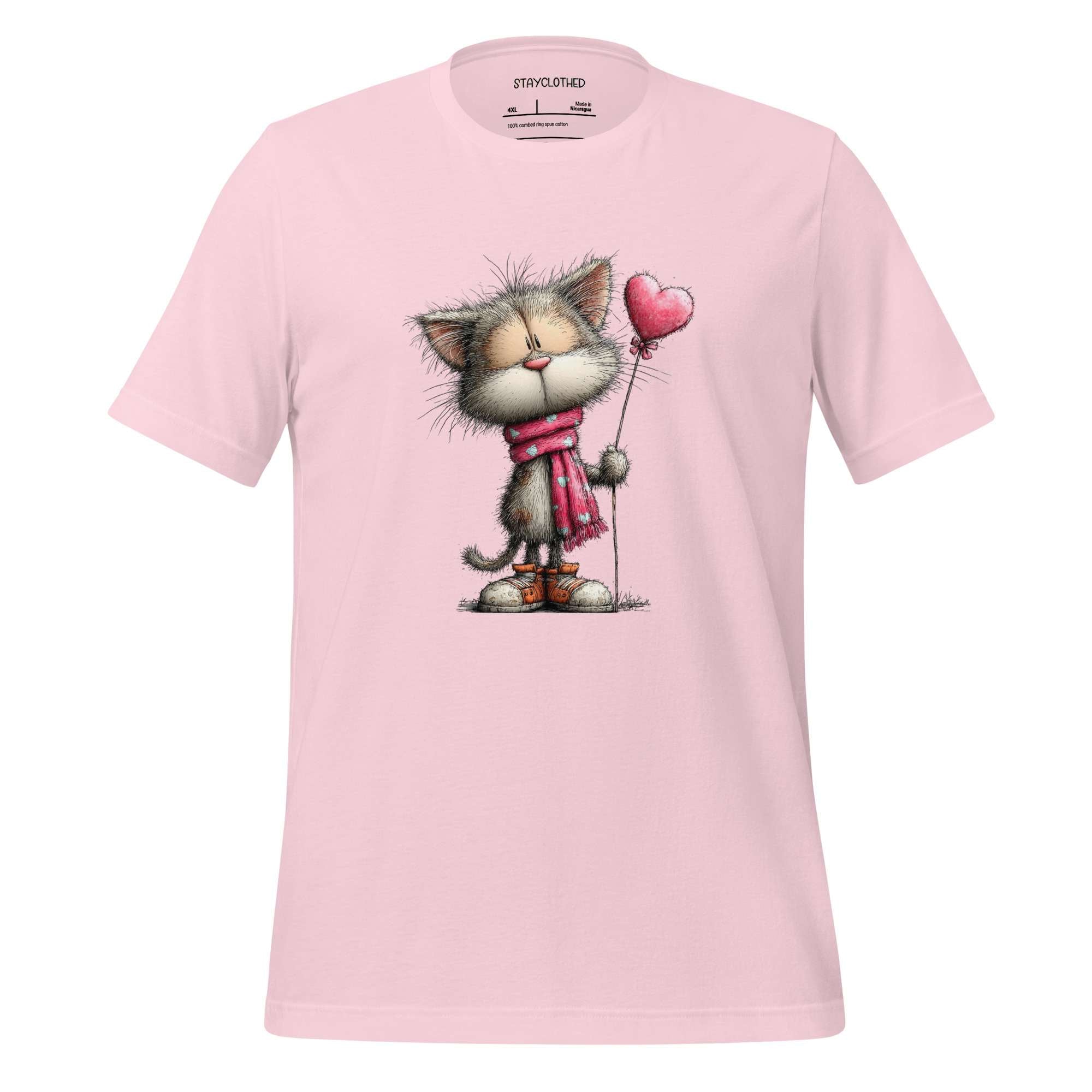 Pink t-shirt with a cat holding a heart balloon design on a wooden surface, featuring the brand 'StayClothed'.