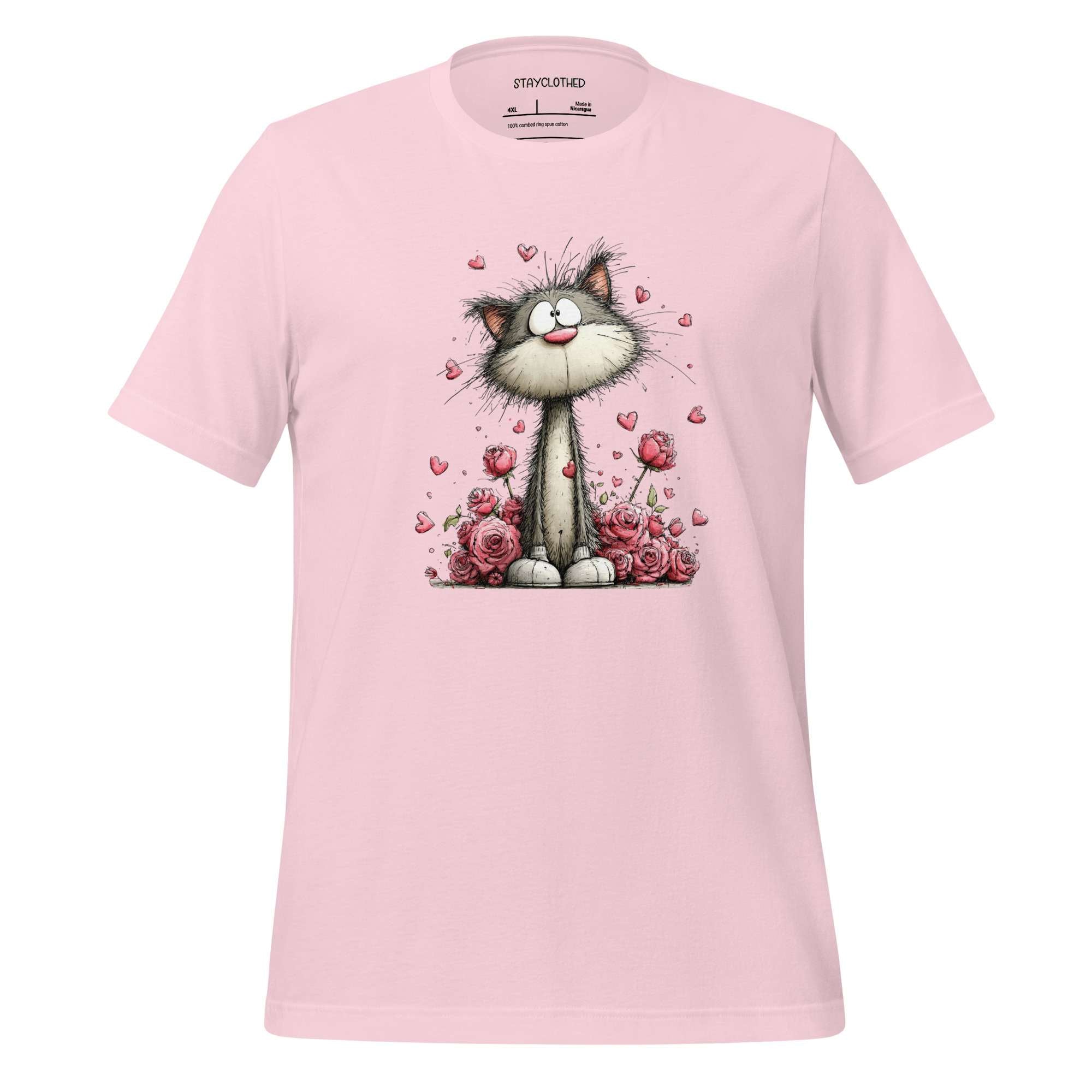 Pink t-shirt with a cat and flower design on a wooden surface, featuring the brand 'StayClothed'.