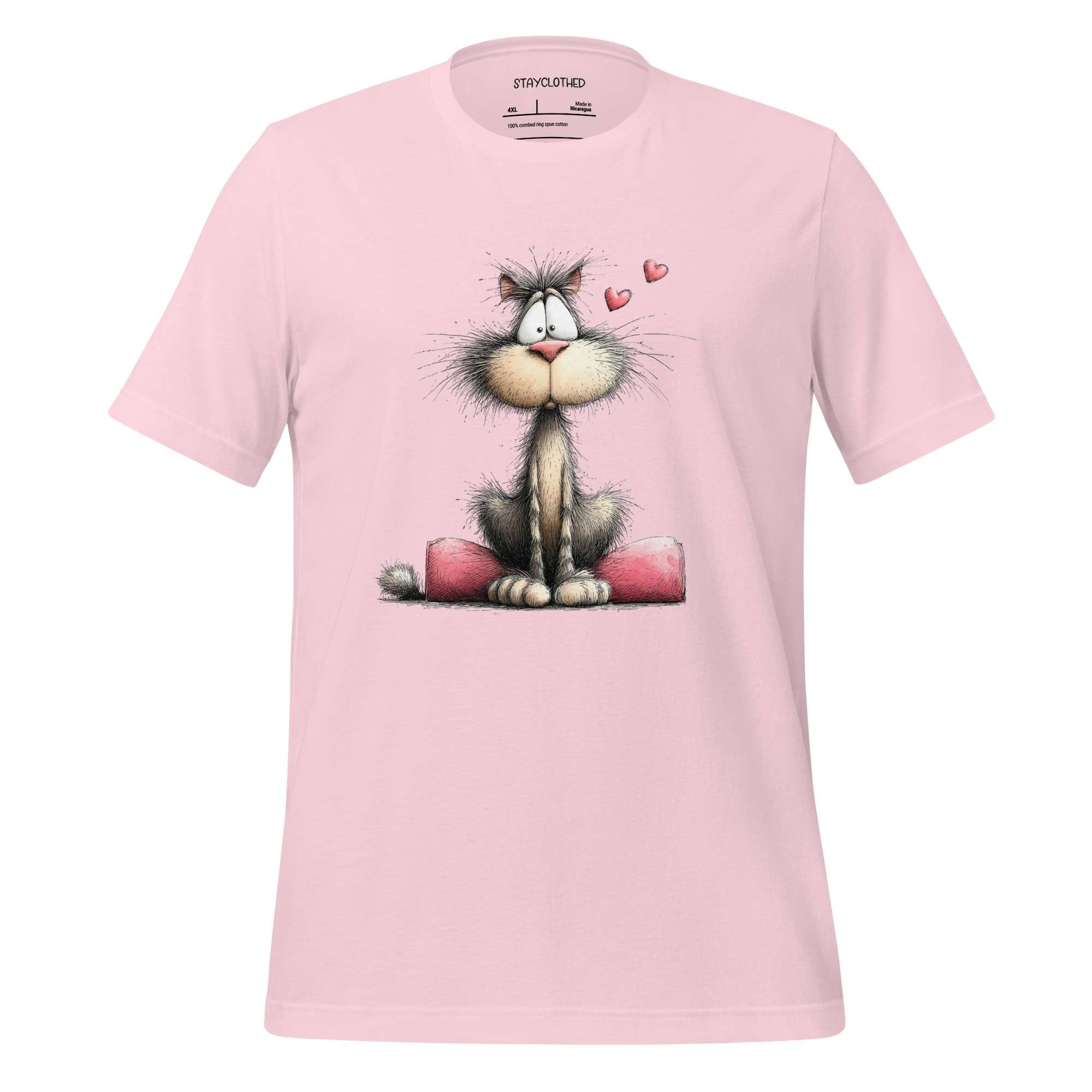 Pink t-shirt with a cartoon cat design on a wooden surface, featuring the brand 'StayClothed'.