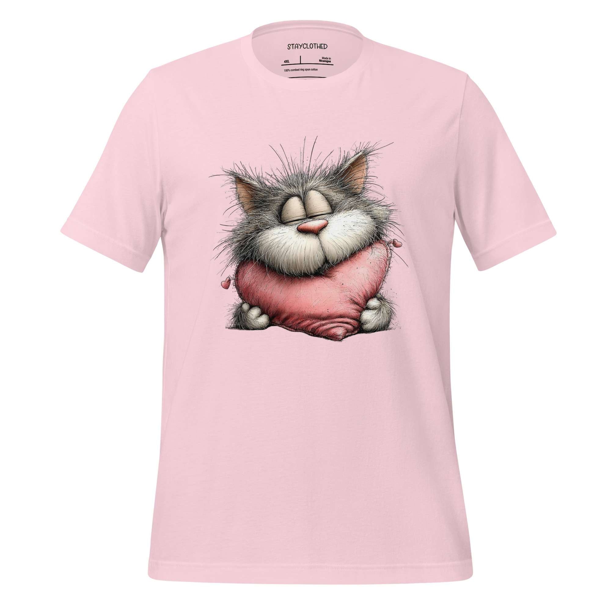 Pink t-shirt with a cartoon cat design on a wooden surface, featuring the brand 'StayClothed'.