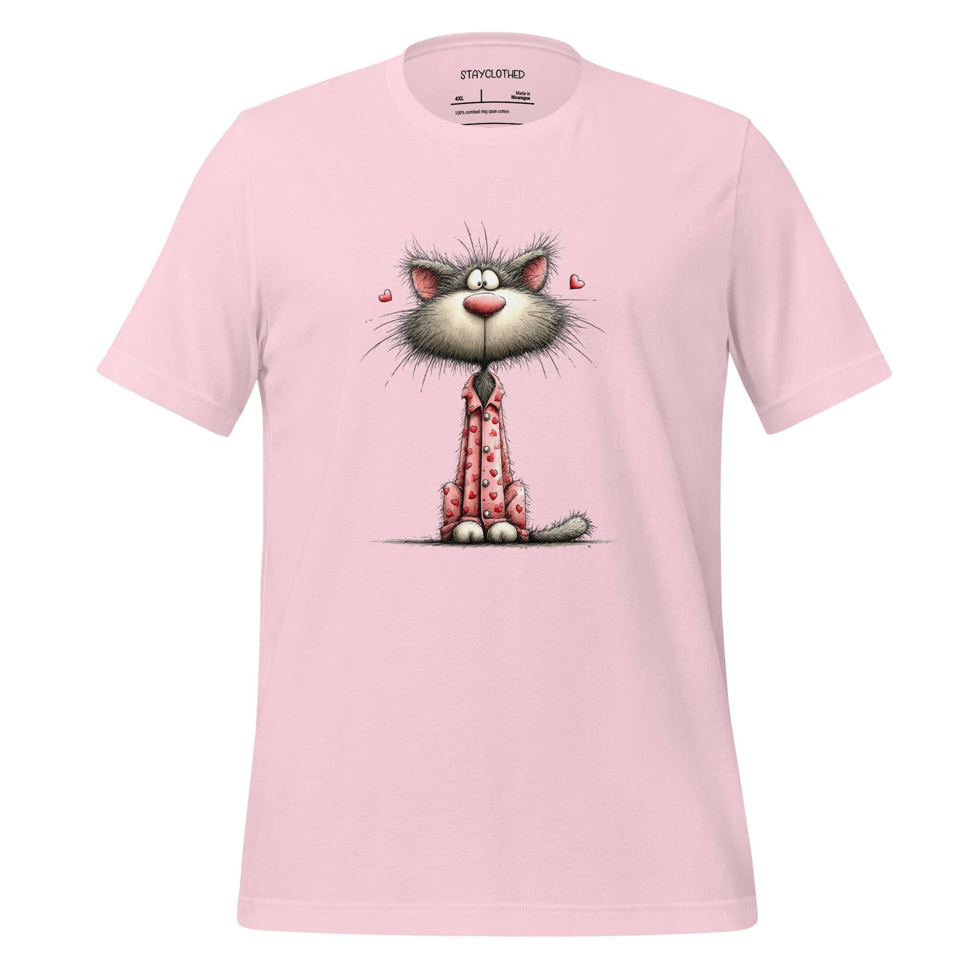 Pink t-shirt with a cartoon cat design on a wooden surface, featuring the brand 'StayClothed'.