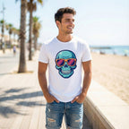 Man wearing a white t-shirt with a colorful skull design on a beach.
