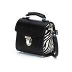 Black handbag with zebra pattern interior on a white background
