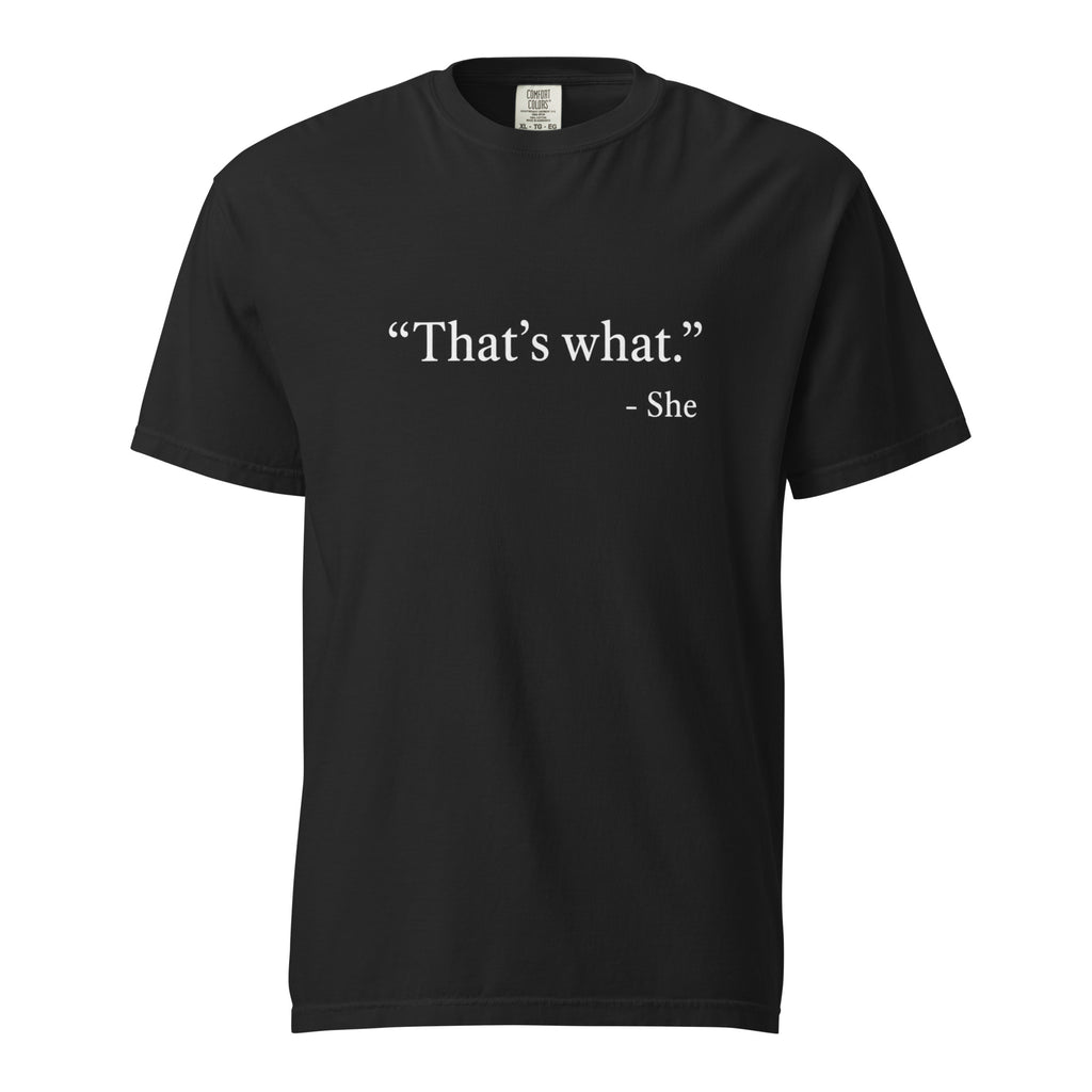 Black T-shirt with minimalist white slogan text reading “That’s what.” and “- She” beneath it, shown from the front.