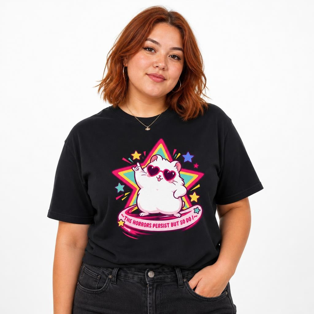 Model wearing a black T-shirt featuring a white cat in heart-shaped sunglasses before a colorful star, with pink text reading “The Horrors Persist But So Do I.”