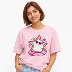Front view of a Blossom T-shirt featuring a kawaii white cat in heart-shaped sunglasses, colorful stars, and pink text reading “THE HORRORS PERSIST BUT SO DO I.”