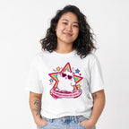 Model wearing a White T-shirt with a kawaii cat in heart-shaped sunglasses before a colorful star and the words “THE HORRORS PERSIST BUT SO DO I.”