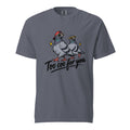 Front of Denim T-Shirt featuring two cartoon pigeons in sunglasses, one in a backwards red cap, above “Too coo for you” with yellow sparkles.