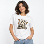 White T-shirt shown on a model, featuring “treat dealer” lettering with a central paw print and three dog-bone illustrations.