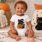 Smiling baby wears a white short-sleeve shirt featuring a black cat in a witch hat holding a pumpkin marked “Trick or Treat?”