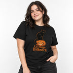 Model wearing a black T-shirt with a seated black cat perched on a sad-faced orange pumpkin and Un-Happy Halloween text.
