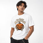 Front view of a model wearing a white T-shirt with “Un-Happy Halloween” above an angry carved pumpkin framed by two skeletal hands.