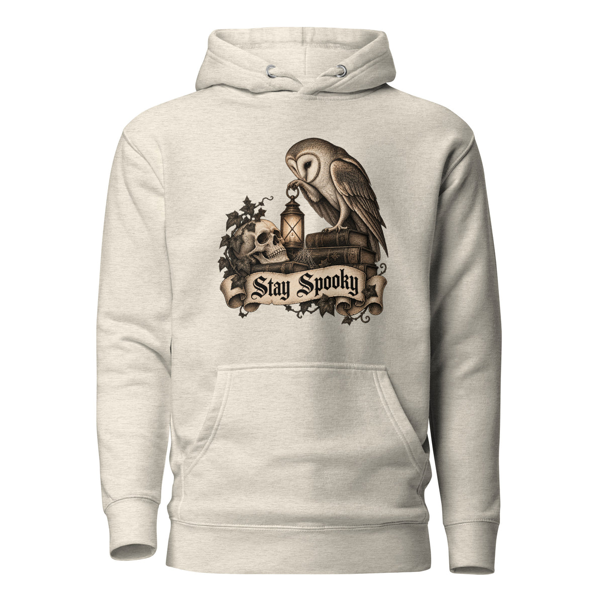 Front view of an Oatmeal Heather hoodie featuring an owl, skull, lantern, foliage, and a “Stay Spooky” banner graphic.