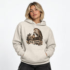 Model wearing an Oatmeal Heather hoodie featuring an owl, skull, lantern, and “Stay Spooky” artwork.