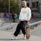 White non-binary person wearing a white autism periodic table sweatshirt.