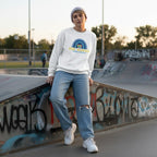 White non-binary person wearing a white be kind autism awareness sweatshirt.