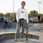 Non-binary person wearing a white heartbeat puzzle sweatshirt.