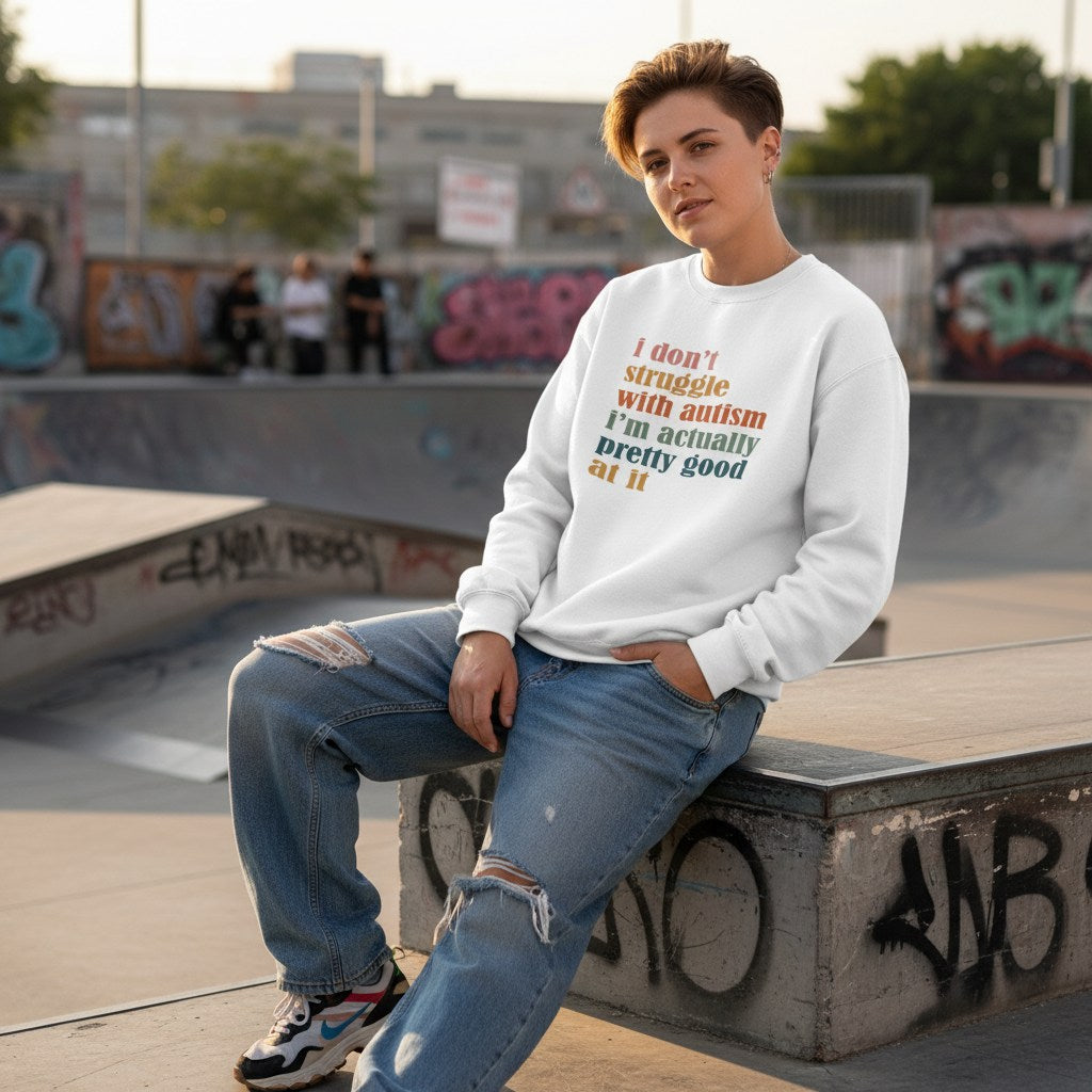 White non-binary person wearing a white "I don't struggle with autism" sweatshirt.
