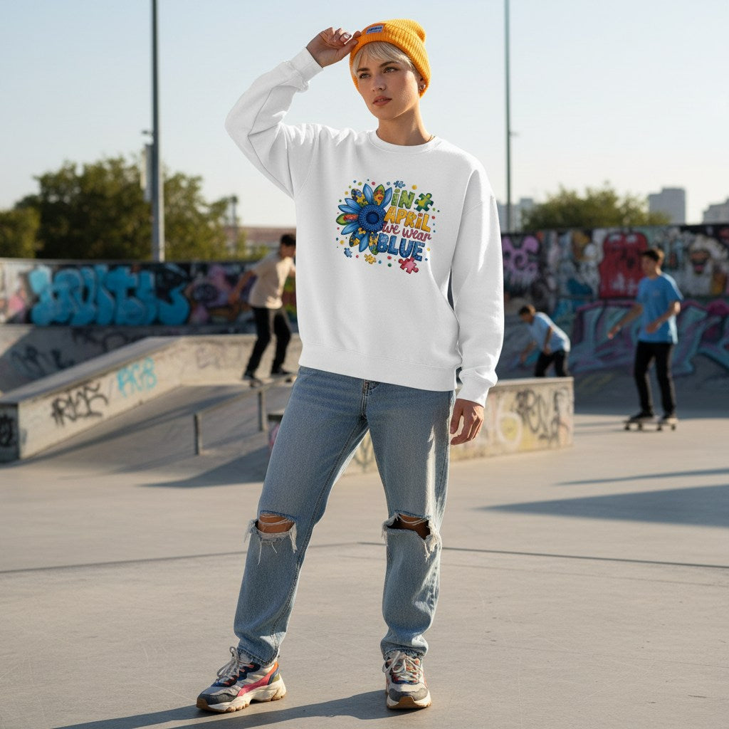 White non-binary person wearing a white autism sunflower sweatshirt.