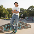 Non-binary person wearing a white autism awareness t-shirt in a streetwear style.