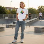 Non-binary person wearing a white puzzle heart autism awareness t-shirt shown from the front.
