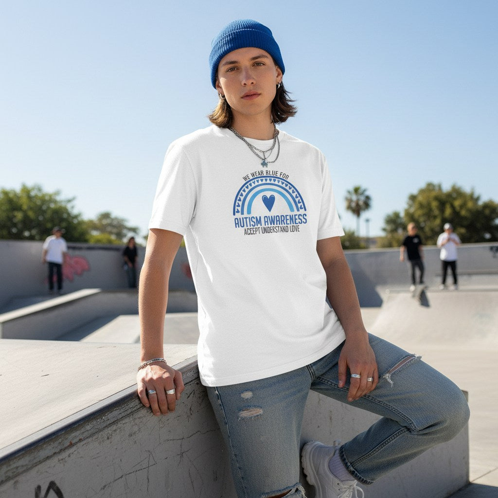 Non-binary person wearing a white "We Wear Blue" autism awareness t-shirt.