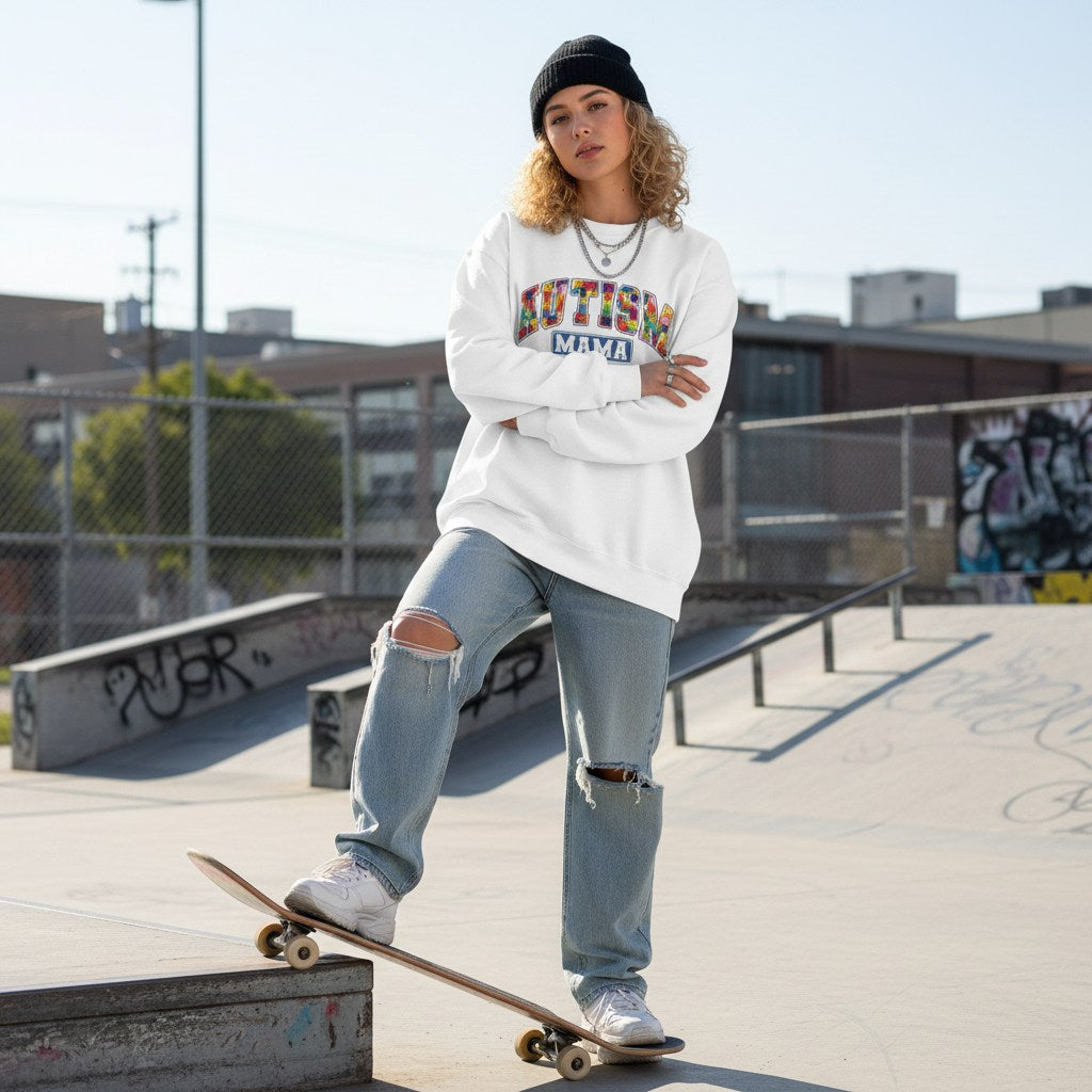 White woman wearing a white autism mama collegiate sweatshirt.