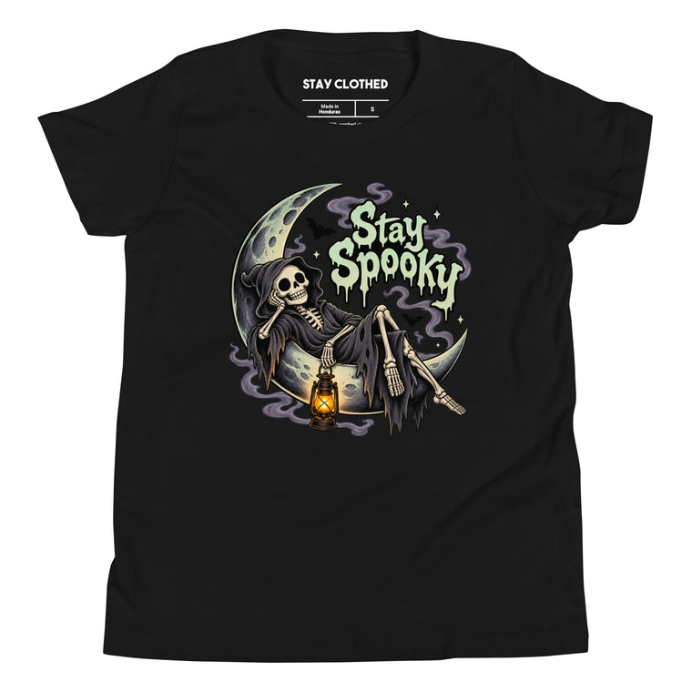 Black T-shirt with a hooded skeleton sitting on a crescent moon, holding a glowing lantern beneath dripping “Stay Spooky” lettering.